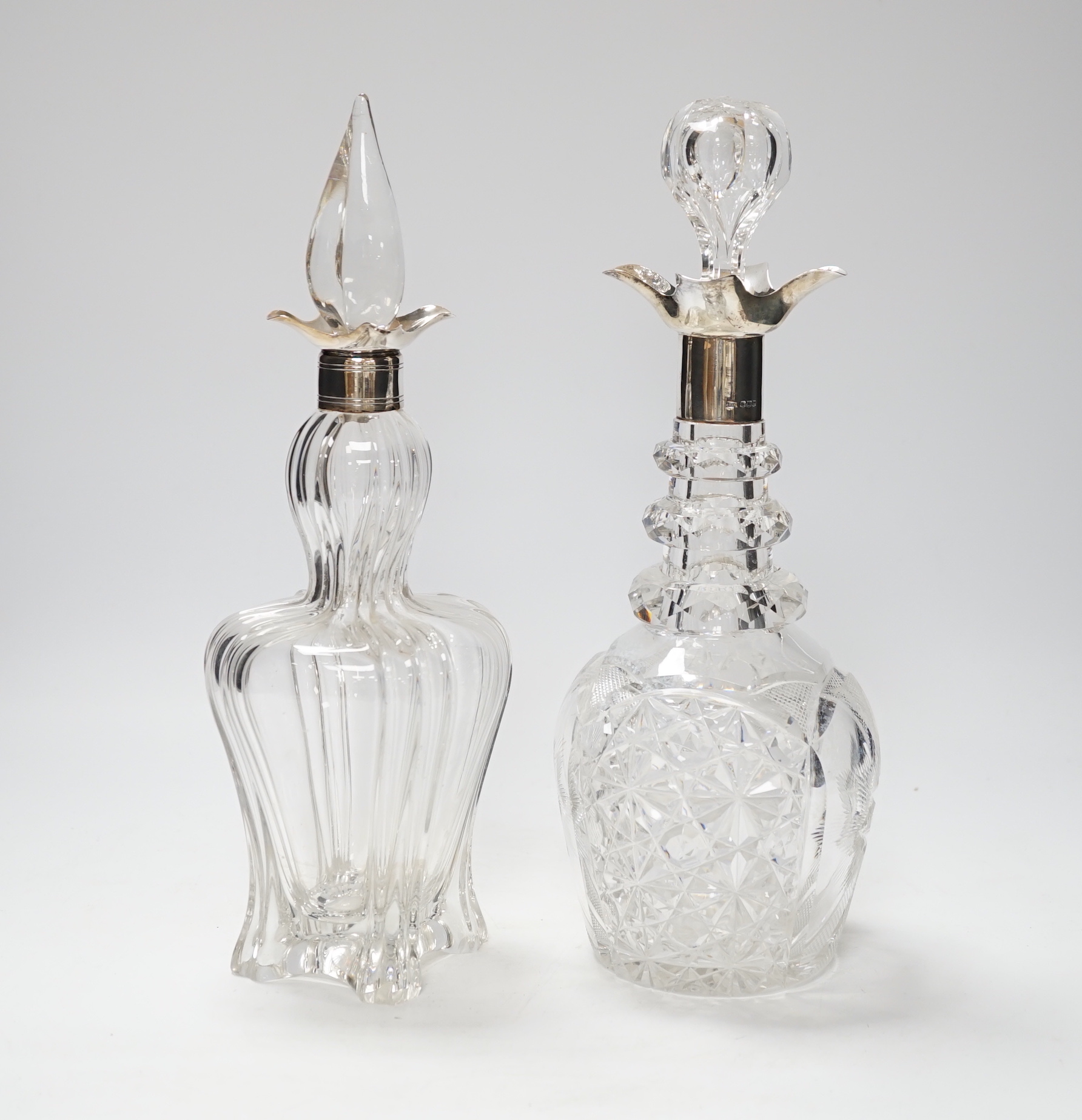 Two early 20th century silver collared cut glass decanters with stoppers, including Sheffield, 1903, tallest 32.3cm.